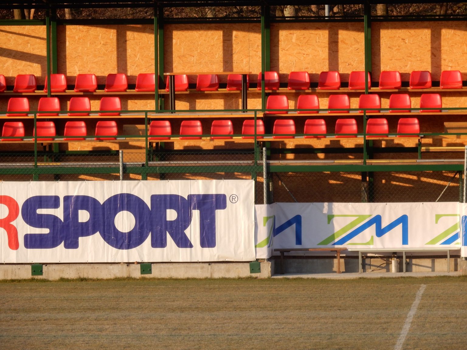 Rdeči sedeži na pokriti tribuni ob glavnem igrišču